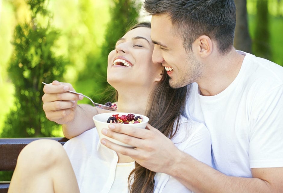 happy couple eating fruit salad
